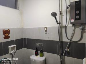 a bathroom with a shower with a toilet and a microphone at Penginapan Puncak 28 in Kuala Terengganu +17 photos