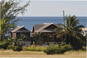 a house on the beach with the ocean in the background at White Coconut Studio in Christ Church