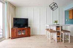 a living room with a television and a table and chairs at Seaside Serenity - Destin, FL in Destin