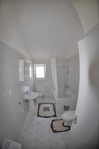 een witte badkamer met een toilet en een wastafel bij Apartments Trogir in Trogir