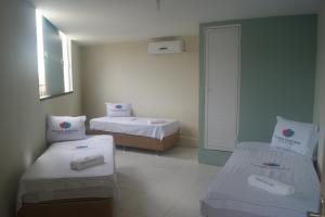 フォルタレザにあるPousada Moda Newのベッドが2つと窓がある小さな部屋