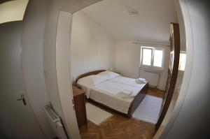 een kleine kamer met een bed en een spiegel bij Apartments Trogir in Trogir