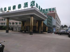 un grand bâtiment avec une écriture chinoise dessus dans l'établissement GreenTree Inn Zhanjiang Haitian Bus Station, à Tchia-k'am