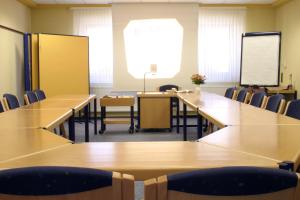 una sala conferenze con tavoli, sedie e lavagna bianca di Spessarter Hof a Hobbach