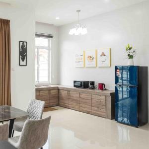 a kitchen with a refrigerator and a table with chairs at Baydream Villa - NEW Private Pool in Langkawi Islands