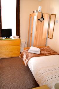 a hotel room with two beds and a mirror at The Avenue Bed and Breakfast in Newcastle upon Tyne