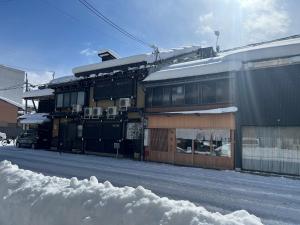un edificio sul lato di una strada innevata di 天满宿 a Takayama