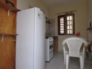 una nevera blanca en una cocina con una silla blanca en Apartamentos Veneza, en Canoa Quebrada