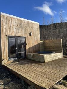 a building with a wooden deck with a large window at Skard Cottages in Fludir