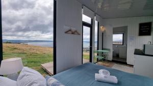 a room with a bed and a view of the water at Aorangi Peak Cabins 8 by Tiny Away in Rotorua