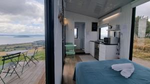 a room with a bed and a balcony with a view at Aorangi Peak Cabins 8 by Tiny Away in Rotorua