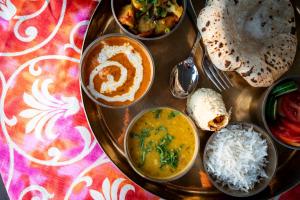 a table topped with different types of food on a plate at All Seasons Heritage Homestay in Jaipur