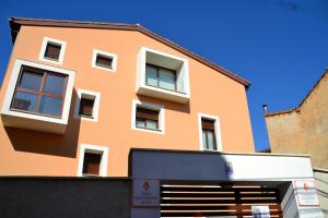 a orange building with white windows and a garage at La Casa de las Aldeas in Daroca