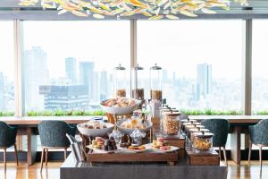 a table with food on it with a view of a city at Hotel Hankyu GRAN RESPIRE OSAKA in Osaka