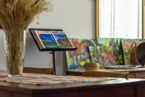 a table with a book on a stand next to a painting at Le Monachette in Ascoli Piceno