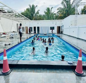 a group of people swimming in a swimming pool at Sam Eden Resort in Bengaluru