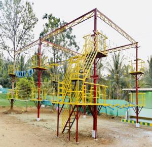 a playground with a yellow slide in a park at Sam Eden Resort in Bengaluru