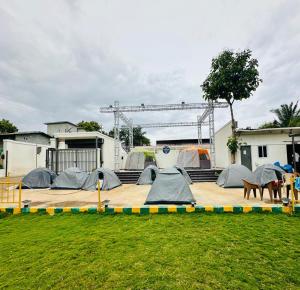 a group of tents sitting on a deck in a yard at Sam Eden Resort in Bengaluru