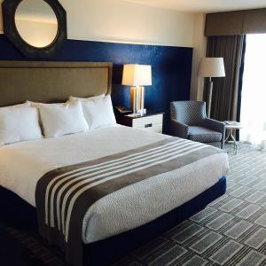 a hotel room with a bed and a mirror at South Shore Harbour Resort and Conference Center in League City