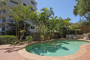 a swimming pool in front of a building at Unit 8 Phoenix Apartments Coolum Beach in Coolum Beach