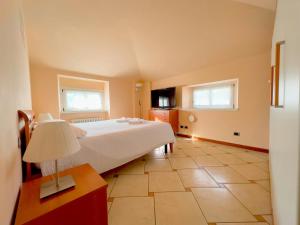 a bedroom with a large white bed and two windows at Centro di Bergamo - Nel Borgo in Bergamo