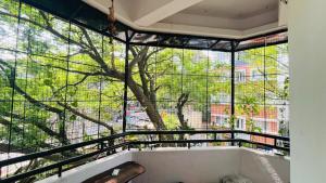 a room with a large window with a tree outside at Your perfect home away from your home in Bengaluru