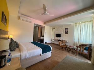 a bedroom with a bed and a living room with a desk at Hotel Bob's N Barley Luxury Room Best Hotel in McLeod Ganj in Dharamshala
