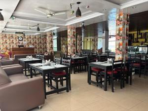 a dining room with tables and chairs in a restaurant at Hotel Bob's N Barley Luxury Room Best Hotel in McLeod Ganj in Dharamshala