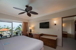 a bedroom with a bed and a flat screen tv at Occidental Caribe - All Inclusive in Punta Cana
