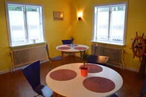 two tables and chairs in a room with windows at MUSES BNB Bed & Breakfast in Bergvik