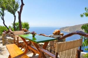 a table and chairs on a patio with a view of the ocean at Pano Gitonia in Aegiali