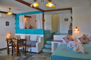 a living room with a bed and a dining room at Pano Gitonia in Aegiali