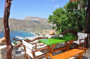 a green table and chairs on a balcony with a view at Pano Gitonia in Aegiali