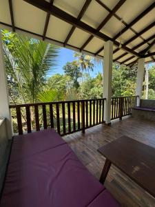 a porch with a table and a wooden deck at Villa Tanzanite in Tangalle