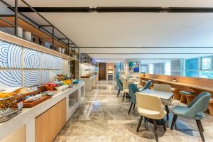 Un restaurante con sillas y mesas y un bar. en Holiday Inn Express Hangzhou Huanglong, en Hangzhou