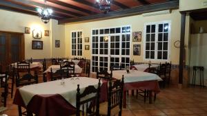 a dining room with tables with white tablecloths at Hostal Restaurante El Lirio in Bollullos par del Condado