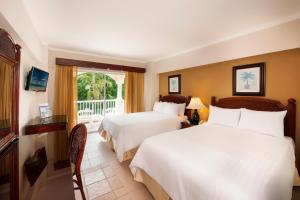 a hotel room with two beds and a balcony at Occidental Caribe - All Inclusive in Punta Cana