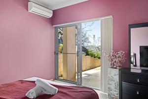 Lilli PilliにあるWaterfront Ensuite Queen Room - Luxury & Comfort Place in Caringbah Southのピンクの壁のベッドルーム(ベッド1台、窓付)