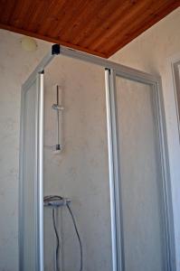 a shower door in a room with a wooden ceiling at MUSES BNB Bed & Breakfast in Bergvik +127 photos