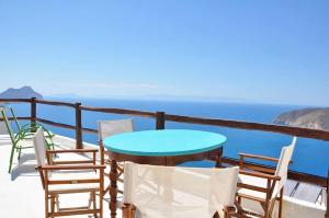 a table and chairs on a balcony overlooking the ocean at Pano Gitonia in Aegiali