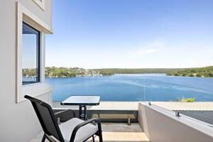 a balcony with a table and chairs and a view of the water at Tranquil Retreat at Caringbah South - Waterfront Ensuite King Room with Spectacular Views in Lilli Pilli +91 photos