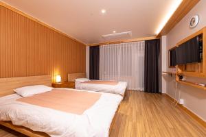 a hotel room with two beds and a flat screen tv at Nine Valley Park in Boeun