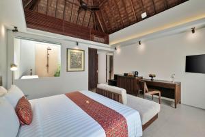 ein Hotelzimmer mit Bett und Schreibtisch in der Unterkunft Mayaloka Villas Ubud in Ubud
