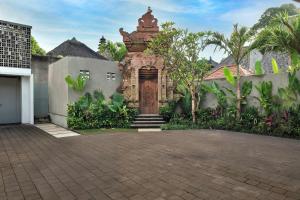 ein Backsteingebäude mit einer Tür im Hof in der Unterkunft Mayaloka Villas Ubud in Ubud