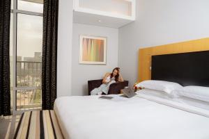 Postel nebo postele na pokoji v ubytování Hala Arjaan by Rotana, Deluxe Hotel Apartments