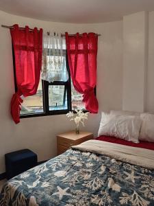 a bedroom with red curtains and a bed and a window at Barnwood Homestay&cafe in Banaue