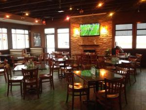 a dining room with tables and chairs and a tv at Western Valley Inn in Valleyview +9 photos