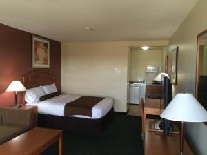 a hotel room with a bed and a kitchen at Western Valley Inn in Valleyview
