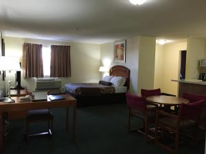 a hotel room with a bed and a table and chairs at Western Valley Inn in Valleyview