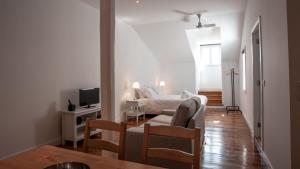 a living room with a bed and a tv at GS Chiado Boutique Studios & Suites in Lisbon